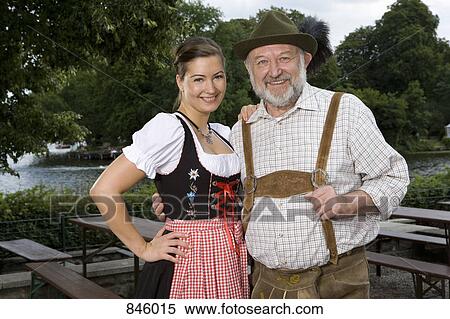 Stock Photography - A traditionally clothed German man and woman in a beer garden, portrait. Fotosearch