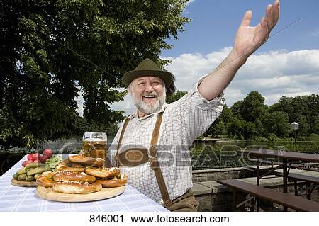 Stock Image - A traditionally clothed German man in a beer garden. Fotosearch