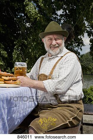 A traditionally clothed German man in a beer garden View Large Photo Image Stock Image - A traditionally clothed German man in a beer garden. Fotosearch