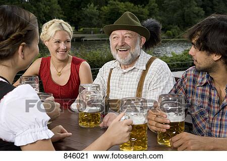 Stock Image - Four people in a beer garden . Fotosearch
