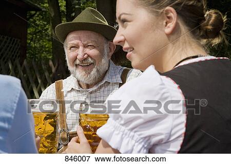 Stock Photo - Three people in a beer garden. Fotosearch