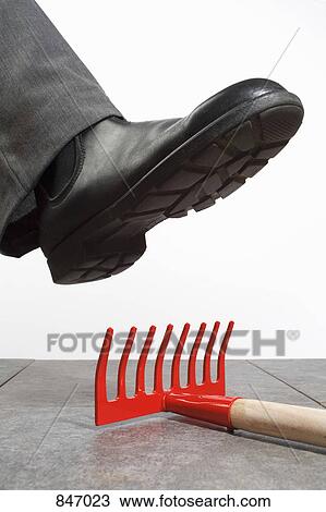 Stock Image - A foot above a rake. Fotosearch