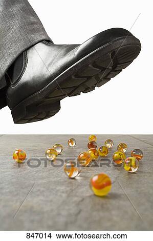 Picture - A foot above scattered marbles. Fotosearch