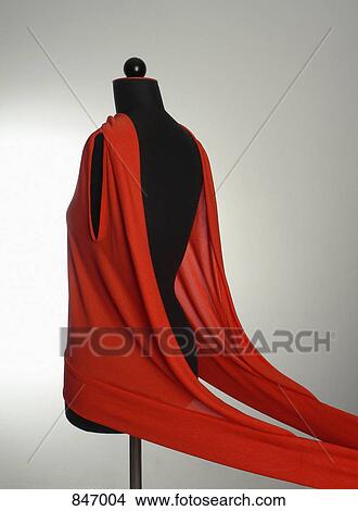 Picture - A red garment on a dressmaking model. Fotosearch