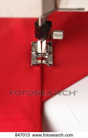 Stock Image - Detail of a sewing machine stitching fabric. Fotosearch