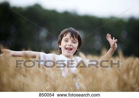 Picture - A boy playing in a wheat field. Fotosearch