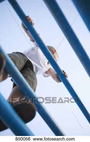 A boy standing on a jungle gym View Large Photo Image Stock Photograph - A boy standing on a jungle gym. Fotosearch