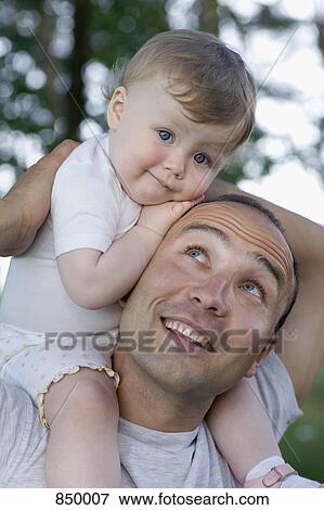 A child sitting on the shoulders of her father View Large Photo Image Stock Photo - A child sitting on the shoulders of her father. Fotosearch