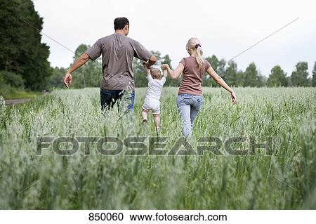 A family walking through a field View Large Photo Image Stock Image - A family walking through a field. Fotosearch