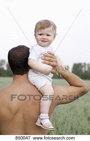 Stock Photo - A father carrying his daughter on his shoulder. Fotosearch