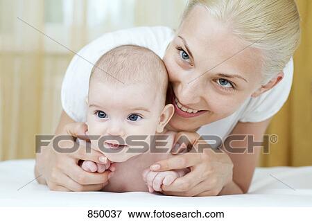 Stock Photo - A mother embracing her baby daughter. Fotosearch