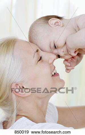 A mother lifting her baby daughter View Large Photo Image Stock Photo - A mother lifting her baby daughter. Fotosearch