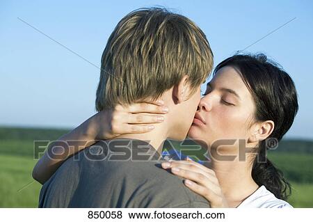 Stock Photo - A young couple kissing. Fotosearch