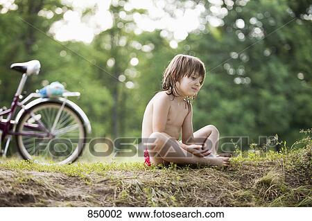 A young girl resting on the floor next to a bicycle View Large Photo Image Stock Image - A young girl resting on the floor next to a bicycle. Fotosearch