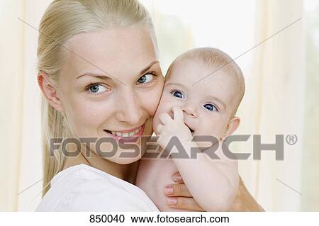 Portrait of a mother holding her baby girl View Large Photo Image Stock Image - Portrait of a mother holding her baby girl. Fotosearch