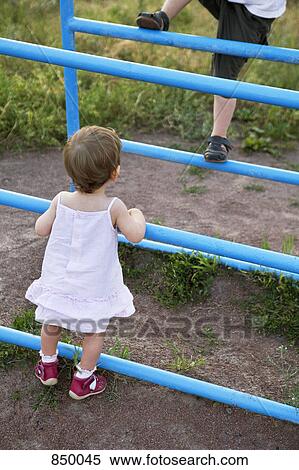 Two children playing on a jungle gym View Large Photo Image Stock Photography - Two children playing on a jungle gym. Fotosearch