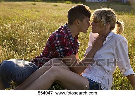 Stock Photo - A young affectionate couple in a park. Fotosearch