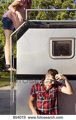 Stock Photo - A young couple and a motor home. Fotosearch