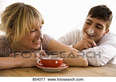 Stock Photo - A young couple balancing spoons on their noses. Fotosearch