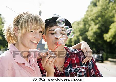 Stock Image - A young couple blowing bubbles. Fotosearch