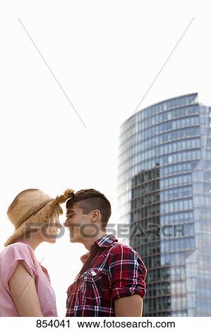 A young couple, face to face, in front of a skyscraper, Berlin, Germany View Large Photo Image Stock Image - A young couple, face to face, in front of a skyscraper, Berlin, Germany. Fotosearch