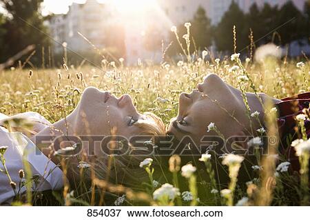 A young couple lying in on their backs in grass, close-up View Large Photo Image Stock Photo - A young couple lying in on their backs in grass, close-up. Fotosearch