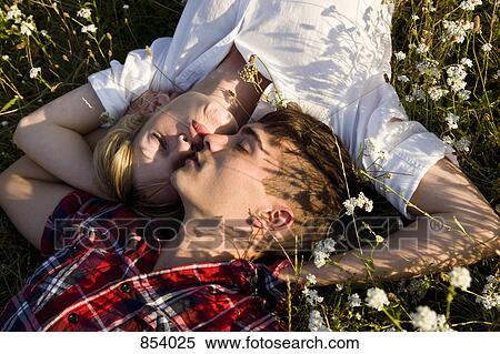 A young couple napping in a field View Large Photo Image Stock Photography - A young couple napping in a field. Fotosearch