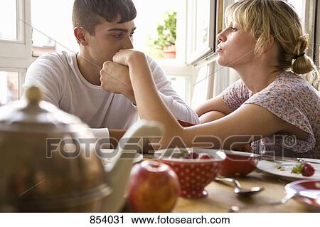 Stock Image - A young couple sitting at the breakfast table. Fotosearch