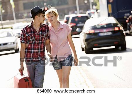 A young couple walking with a suitcase View Large Photo Image Stock Image - A young couple walking with a suitcase. Fotosearch