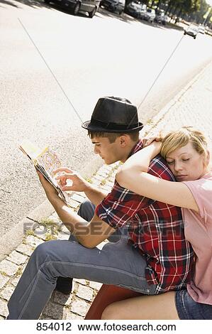 Stock Image - A young couple with a suitcase and a map. Fotosearch