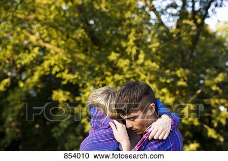 Stock Image - A young couple wrapped in a blanket. Fotosearch