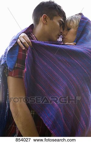 A young couple wrapped in a blanket View Large Photo Image Stock Photo - A young couple wrapped in a blanket. Fotosearch