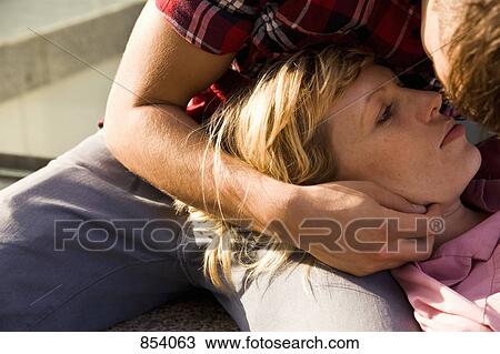 A young man cradling a young woman's head in his lap View Large Photo Image Stock Image - A young man cradling a young woman's head in his lap. Fotosearch