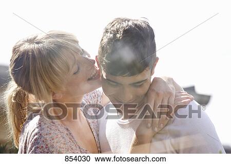 A young woman playfully licking a young man's ear View Large Photo Image Stock Image - A young woman playfully licking a young man's ear . Fotosearch