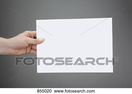 Stock Image - A hand holding up a white piece of paper. Fotosearch