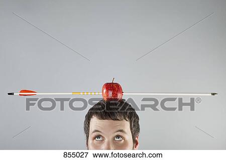 A man with an apple on top of his head and an arrow piercing it View Large Photo Image Stock Photo - A man with an apple on top of his head and an arrow piercing it. Fotosearch