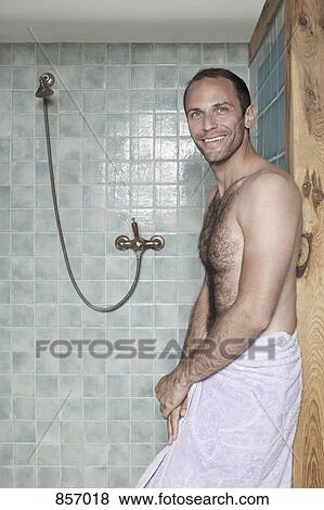 A man wrapped in a towel standing by a shower at a spa View Large Photo Image Stock Photo - A man wrapped in a towel standing by a shower at a spa. Fotosearch