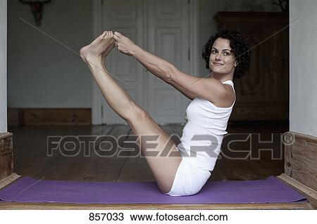 A woman doing the yoga boat pose View Large Photo Image Stock Image - A woman doing the yoga boat pose. Fotosearch