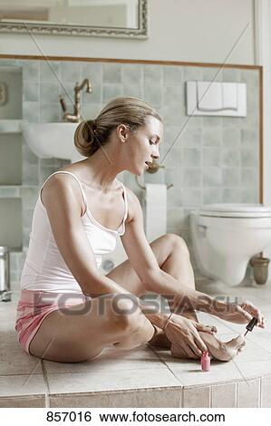 A woman painting her toenails in a health spa bathroom View Large Photo Image Stock Photograph - A woman painting her toenails in a health spa bathroom. Fotosearch