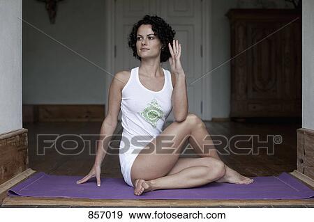 A woman practicing the yoga pose Ardha Matsyendrasana View Large Photo Image Stock Photo - A woman practicing the yoga pose Ardha Matsyendrasana. Fotosearch