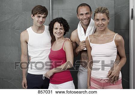 Stock Image - Four friends standing in the shower area of a health spa. Fotosearch