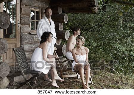 Four people relaxing outside the sauna at a health spa View Large Photo Image Stock Photo - Four people relaxing outside the sauna at a health spa. Fotosearch