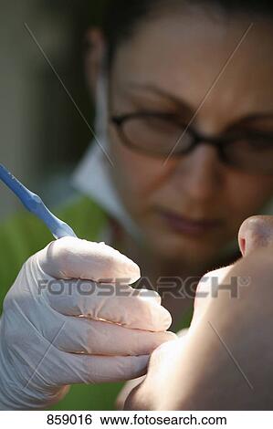 Close-up of a dentist working on a female patient View Large Photo Image Stock Photograph - Close-up of a dentist working on a female patient. Fotosearch