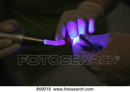 Detail of a dentist using UV light View Large Photo Image Stock Photo - Detail of a dentist using UV light . Fotosearch
