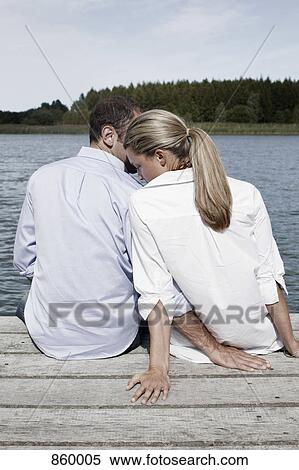 A couple being affectionate on a jetty View Large Photo Image Stock Photography - A couple being affectionate on a jetty. Fotosearch