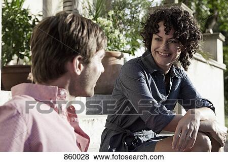 Stock Photo - A man and woman relaxing on the front stoop. Fotosearch