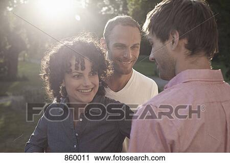 A man chatting with two friends View Large Photo Image Stock Image - A man chatting with two friends. Fotosearch