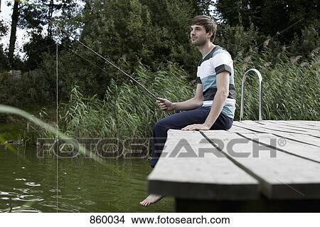 A man fishing off a jetty View Large Photo Image Picture - A man fishing off a jetty. Fotosearch