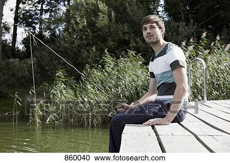 A man fishing off a jetty View Large Photo Image Stock Image - A man fishing off a jetty. Fotosearch