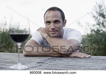 A man sitting at an outdoor table, non-urban scene View Large Photo Image Stock Photo - A man sitting at an outdoor table, non-urban scene. Fotosearch
